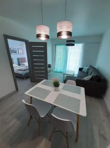 een woonkamer met een tafel en stoelen en een bank bij Apartament Aniutka in Międzyzdroje