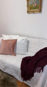 a white bed with pillows and a picture on the wall at Landhaus nähe Neusiedler See in Jois