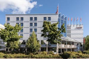 un gran edificio blanco con banderas delante en Scandic Jyväskylä Station, en Jyväskylä