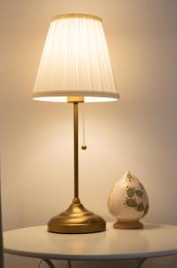 a lamp on a table with a vase on it at PURA B&b in Noicattaro
