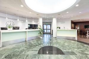an office lobby with a marble floor and a reception counter at Scandic Patria in Lappeenranta