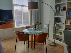 een eettafel met stoelen en een vloerlamp bij B&B Hart van Leiden in Leiden