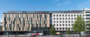 un gran edificio con un autobús delante en Scandic Tampere City, en Tampere