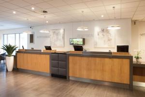 an office lobby with a reception desk and a tv at Scandic Asker in Asker