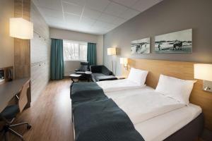 a hotel room with a bed and a desk at Scandic Asker in Asker