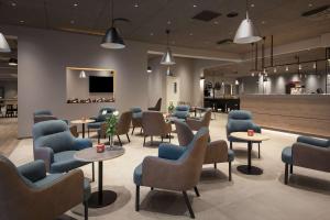 a waiting room with blue chairs and tables at Scandic Kokstad in Bergen