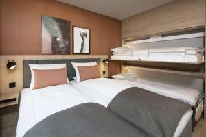 two beds in a room with two bunk beds at Scandic Kokstad in Bergen