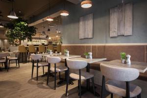 a restaurant with tables and chairs in a room at Scandic Kokstad in Bergen