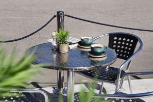 une table et des chaises bleues avec deux tasses dessus dans l'établissement Scandic Kokstad, à Bergen