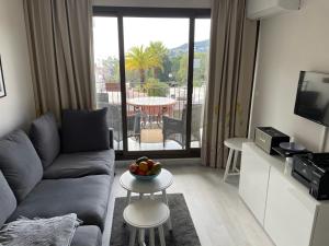 a living room with a couch and a table at Nyrenoverad lägenhet med havsutsikt in Villefranche-sur-Mer