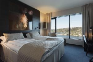 a bedroom with a large bed and a large window at Scandic Havet in Bodø