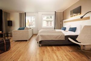 um quarto com uma cama grande e uma cadeira em Scandic Haugesund em Haugesund