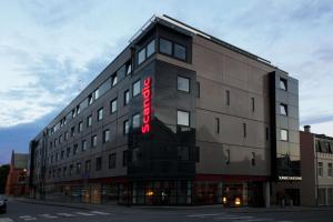 a building with a red sign on the side of it at Scandic Haugesund in Haugesund