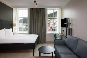 une chambre d'hôtel avec un lit et un canapé dans l'établissement Scandic Torget Bergen, à Bergen