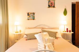 a bedroom with a white bed with two lamps at PURA B&b in Noicattaro