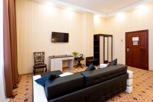 a living room with a black couch and a television at AFFONYKATE hotel - "АФФОНИКЕЙТ отель" in Moscow