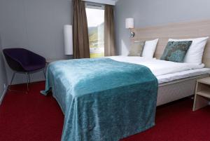 una habitación de hotel con una cama grande y una silla en Scandic Nordkapp en Honningsvåg