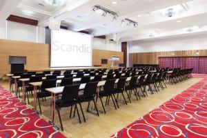 a lecture hall with rows of chairs and a screen at Scandic Alta in Alta