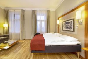 una camera d'albergo con un grande letto e un divano di Scandic Holberg a Oslo