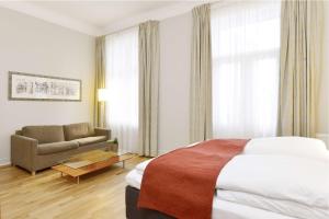 オスロにあるスカンディック ホルベルクのベッドとソファ付きのホテルルーム