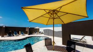 a yellow umbrella sitting next to a swimming pool at St Paul Plaza Hotel in Brasilia