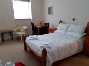 a bedroom with a bed and a table and chairs at The Edenhurst Guesthouse in Weymouth