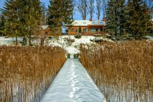 a snow covered path in front of a house at Dom Mazurski Tumiany 3 B in Tumiany