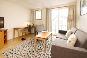 ein Wohnzimmer mit einem Sofa und einem Tisch in der Unterkunft Clarion Collection Hotel Grimstad in Grimstad