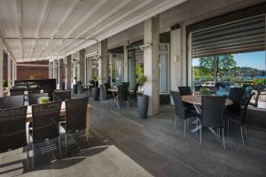 eine Terrasse mit Tischen und Stühlen auf einem Gebäude in der Unterkunft Scandic Park Sandefjord in Sandefjord