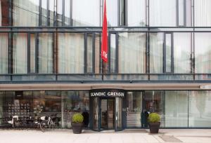 a store front of a glass building with a flag at Scandic Grensen in Oslo