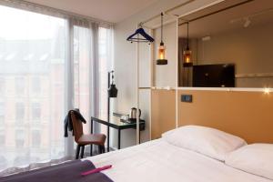 1 dormitorio con cama, escritorio y ventana en Scandic Grensen en Oslo