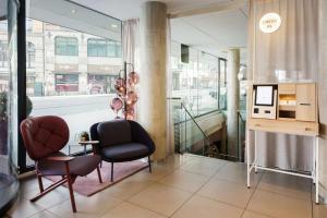 a lobby with two chairs and a table and a window at Scandic Grensen in Oslo