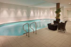 哈山的住宿－哈山斯堪迪克酒店，一个带椅子和桌子的大型游泳池