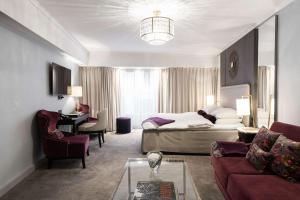 una camera d'albergo con letto e soggiorno di Grand Hotel Oslo a Oslo