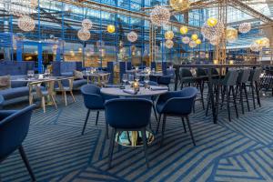 a dining room with tables and chairs and chandeliers at Scandic Helsinki Airport in Vantaa