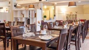 une salle à manger avec des tables et des chaises en bois dans l'établissement Scandic Leknes Lofoten, à Leknes