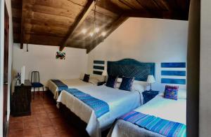a bedroom with three beds in a room at Hotel la Galería in Antigua Guatemala