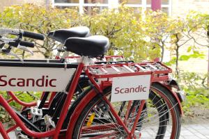 two red bikes parked next to each other with signs on them at Scandic Meilahti in Helsinki