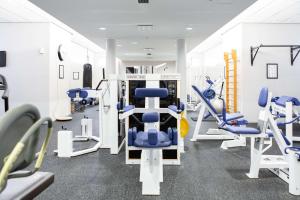 a gym with blue chairs and tread machines at Scandic Helsinki Aviapolis in Vantaa