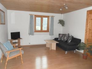 a living room with a black couch and a table at Ferienwohnungen Brunner in Fischen