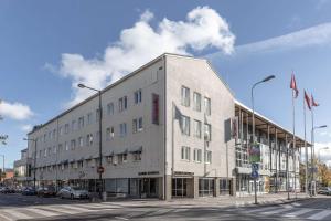 a large white building on the corner of a street at Scandic Kouvola in Kouvola