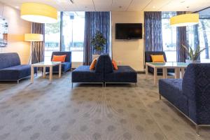 una sala de espera con sofás y mesas azules y TV en Scandic Hakaniemi, en Helsinki