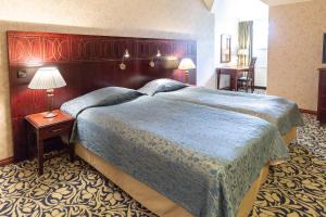 イマトラにあるScandic Imatran Valtionhotelliの大きなベッドとテーブルが備わるホテルルームです。