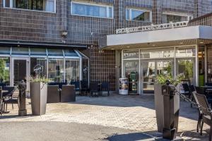 a store front of a building with tables and chairs at Scandic Jyväskylä City in Jyväskylä