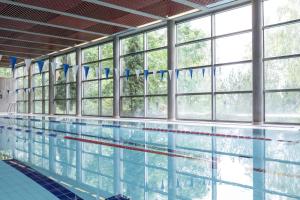 a large swimming pool with windows and water in it at Scandic Siuntio in Sjundeå