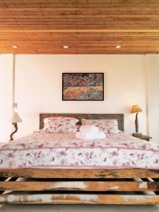 ein Schlafzimmer mit einem großen Bett und einer Holzdecke in der Unterkunft Pousada Estaleiro Village - Frente Mar in Balneário Camboriú