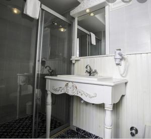 a bathroom with a white sink and a shower at The White Hotel Alaçatı in Alaçatı +33 photos