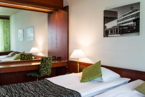 ロヴァニエミにあるスカンディック ポーラーのベッド2台と鏡が備わるホテルルームです。