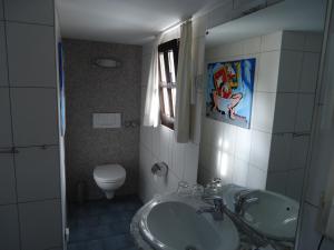 een badkamer met een wastafel en een toilet bij Am Alten Fronhof in Bergisch Gladbach