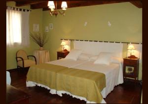 una camera da letto con un grande letto bianco con due lampade di La Casa de la Abuela Petra a Solarana
